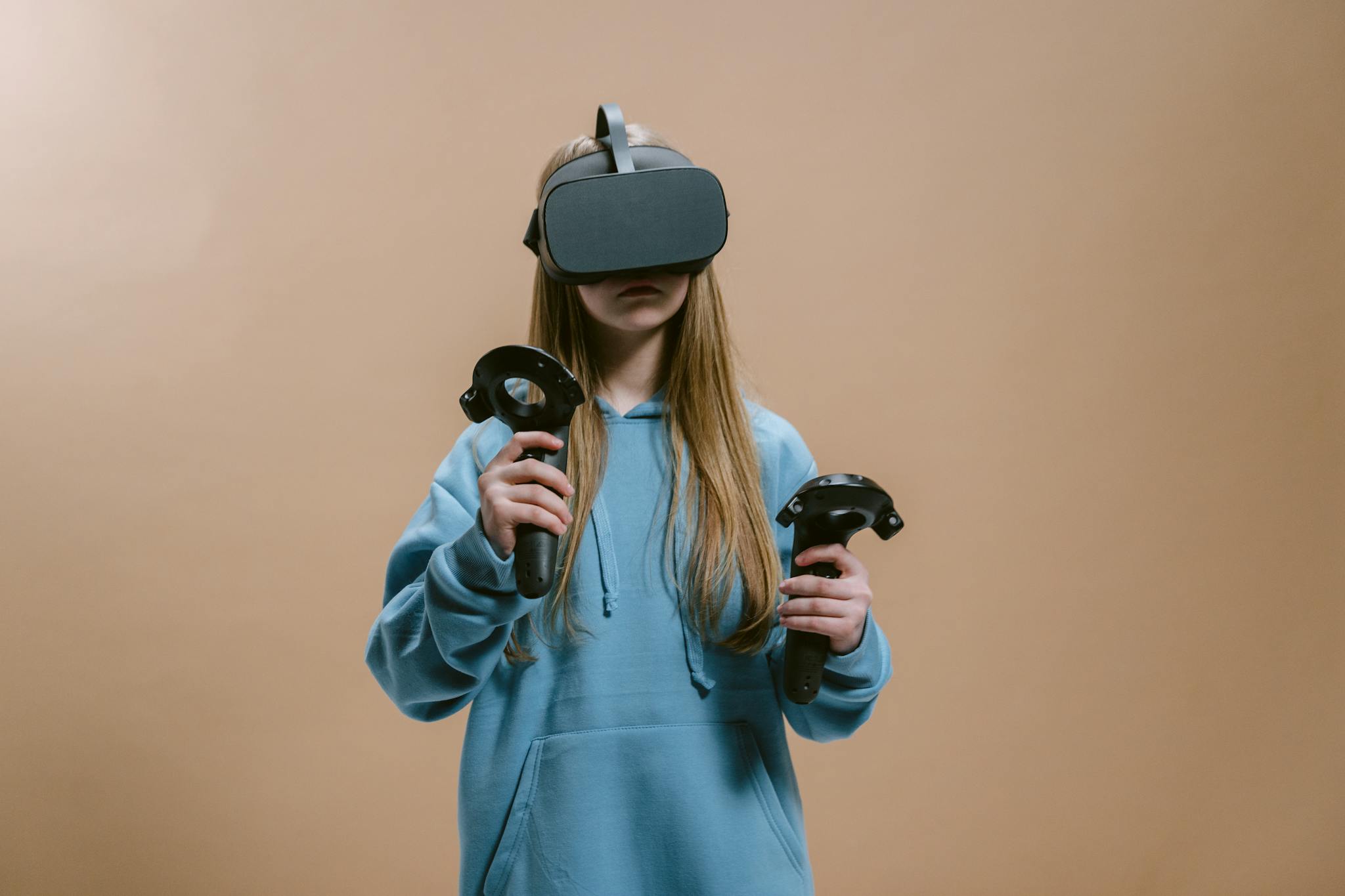 Woman using virtual reality headset with controllers indoors.
